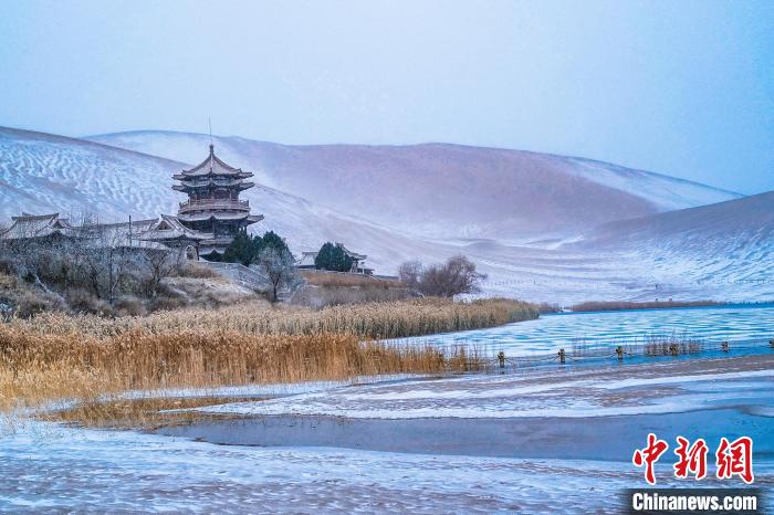 2021年11月28日，雪落鳴沙山月牙泉景區(qū)。　王斌銀 攝