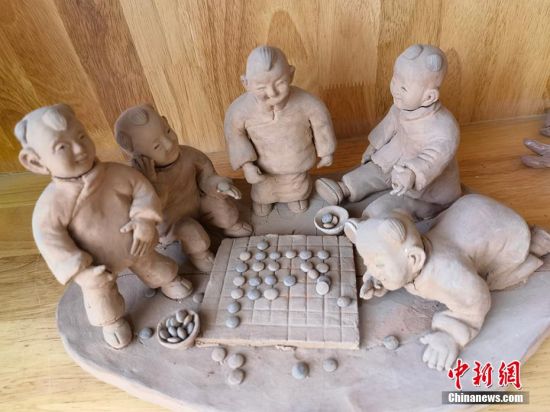 圖為泥塑作品展現(xiàn)下棋場景。 劉玉桃 攝