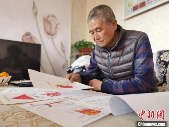 圖為陸鵬飛向記者展示多年帶隊(duì)的手寫筆記?！堟?攝