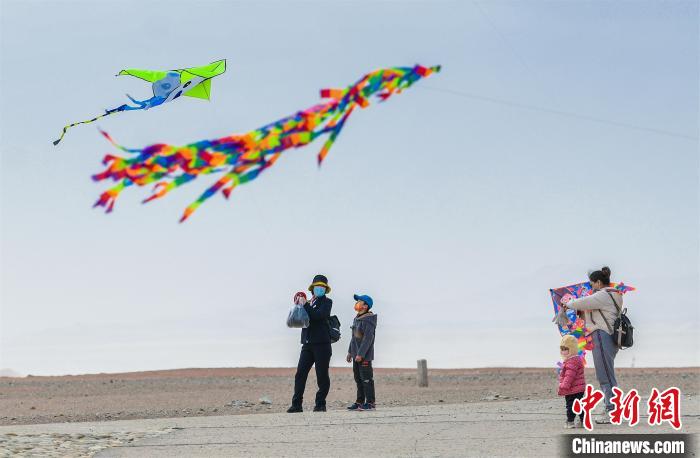 圖為孩童在父母的陪伴下放風(fēng)箏。　王斌銀 攝