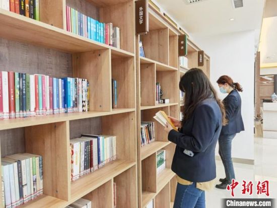 圖為在甘肅公航旅建設(shè)集團(tuán)有限公司的職工書屋，職工挑選書籍?！⌒煅?攝