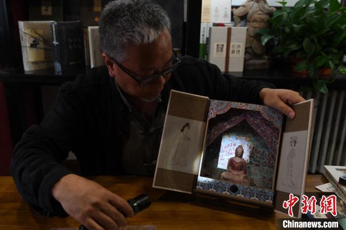 圖為讀者出版集團讀者晉林工作室獨立出品人徐晉林，展示互動性強的敦煌題材手工書。(資料圖) 楊艷敏 攝