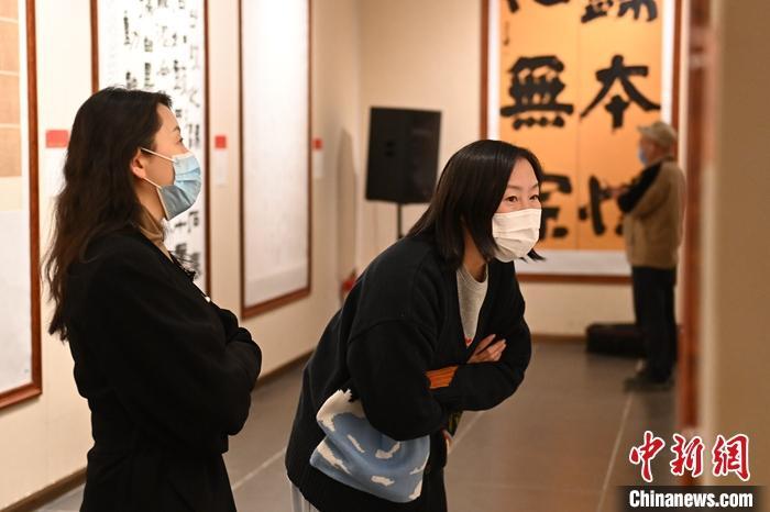 圖為甘肅蘭州，參展書(shū)法作品吸引參觀者。 中新社記者 李亞龍 攝