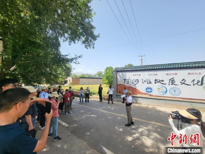 圖為中國地質(zhì)大學(xué)(北京)教授張緒教介紹村落情況?！『衍?攝