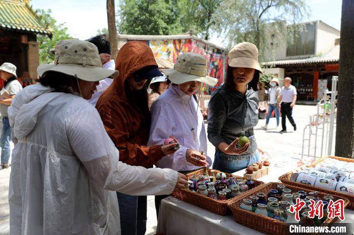 圖為民眾挑選手工藝產(chǎn)品?！⊙Φ?攝