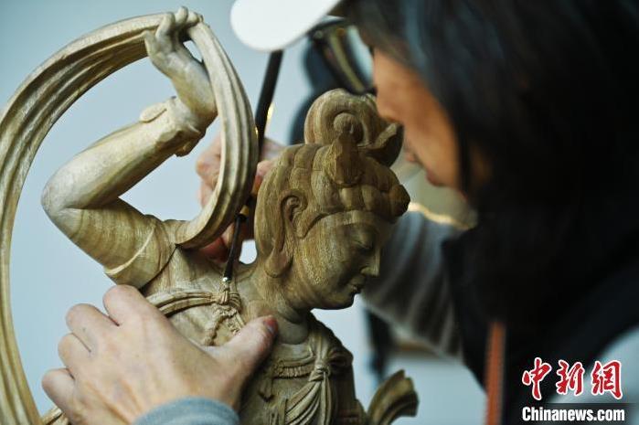 圖為季茂杰進(jìn)行敦煌元素的木雕創(chuàng)作。李亞龍 攝</p>
<p>