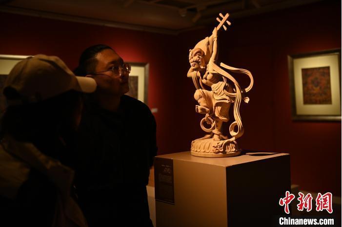 圖為季茂杰向參觀者介紹自己創(chuàng)作敦煌木雕的過程。李亞龍 攝</p>
<p>