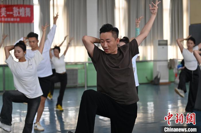 6月6日，在甘肅敦煌青年夜校課程中，青年學(xué)員學(xué)習(xí)敦煌舞課程。李亞龍 攝　　