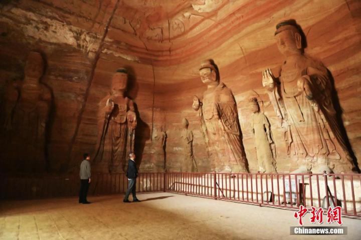 7月15日，游人參觀甘肅省平?jīng)鍪袥艽h百里石窟長廊中的南石窟寺1號窟。百里石窟長廊位于涇川縣境內(nèi)，由512個石窟、5眼窟中石井組成，現(xiàn)存王母宮石窟、鳳凰山石窟、南石窟寺、丈八寺石窟、羅漢洞石窟、太山寺石窟等規(guī)模較大的石窟群，還有數(shù)量眾多的小石窟群。南石窟寺開鑿于北魏永平三年，其中1號窟屬于大型七佛窟，七佛高達6米。中新社記者 李亞龍 攝