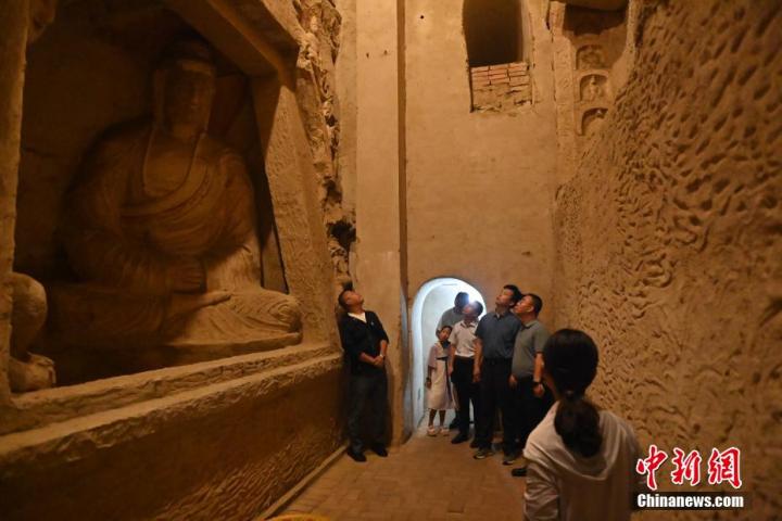 7月15日，游人參觀甘肅省平?jīng)鍪袥艽h百里石窟長廊中的王母宮石窟。百里石窟長廊位于涇川縣境內(nèi)，由512個石窟、5眼窟中石井組成，現(xiàn)存王母宮石窟、鳳凰山石窟、南石窟寺、丈八寺石窟、羅漢洞石窟、太山寺石窟等規(guī)模較大的石窟群，還有數(shù)量眾多的小石窟群。王母宮石窟又名千佛洞，該窟設(shè)計宏大，造像生動，窟內(nèi)擁有造像數(shù)百尊，是較為珍貴的佛教文化歷史遺存。中新社記者 李亞龍 攝</p>
<p>