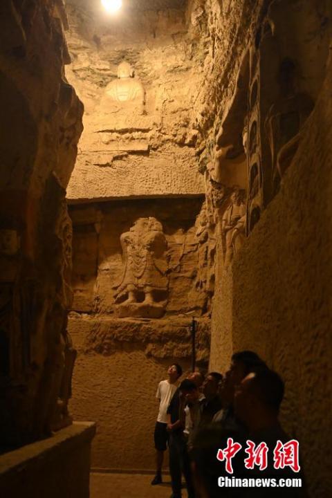 7月15日，游人參觀甘肅省平?jīng)鍪袥艽h百里石窟長廊中的王母宮石窟。百里石窟長廊位于涇川縣境內(nèi)，由512個石窟、5眼窟中石井組成，現(xiàn)存王母宮石窟、鳳凰山石窟、南石窟寺、丈八寺石窟、羅漢洞石窟、太山寺石窟等規(guī)模較大的石窟群，還有數(shù)量眾多的小石窟群。王母宮石窟又名千佛洞，該窟設(shè)計宏大，造像生動，窟內(nèi)擁有造像數(shù)百尊，是較為珍貴的佛教文化遺存。中新社記者 李亞龍 攝</p>
<p>